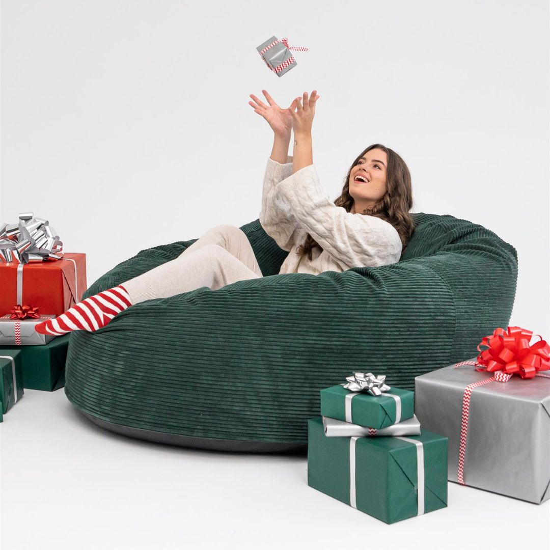 Kvinna som leker med julklappar i en sittsäck till barn, perfekta presenten för barn och ungdomar.