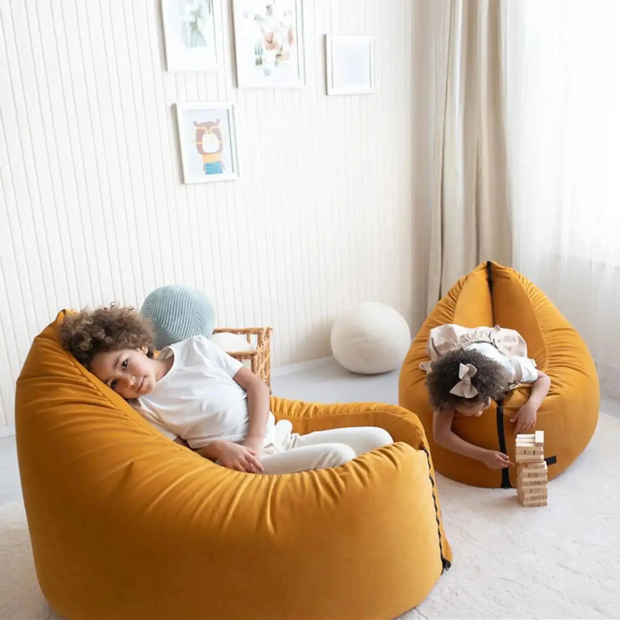Barn som leker och kopplar av i flexibel sittsäck för barn i ett ljust rum.