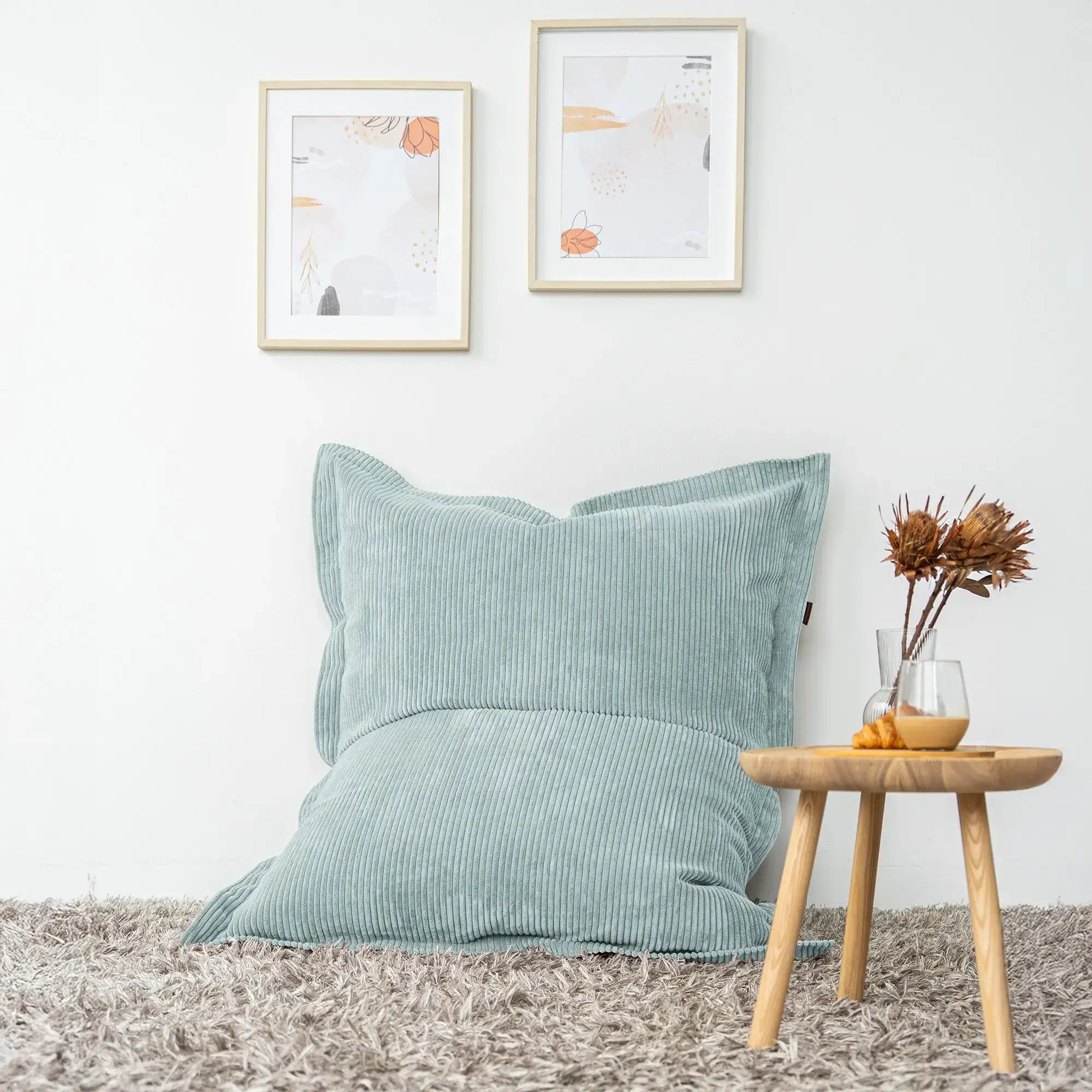 Klassiska sittsäckar i blått med väggkonst och ett litet bord i en avkopplande inredning.