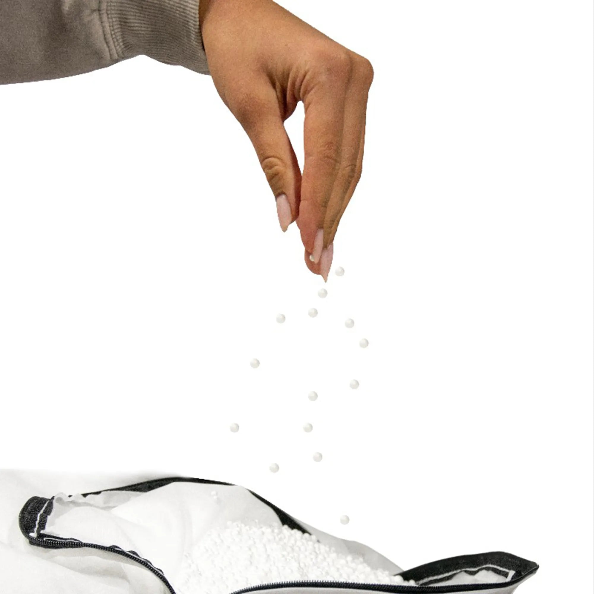 Hånd som strör cellplastkulor i en sittsäck fyllning 100 liter för att återställa formen.