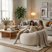 Two women relaxing on a cozy Fåtölj Sittsäck Om 135 Waves Snow beanbag chair in a stylish, modern living room.