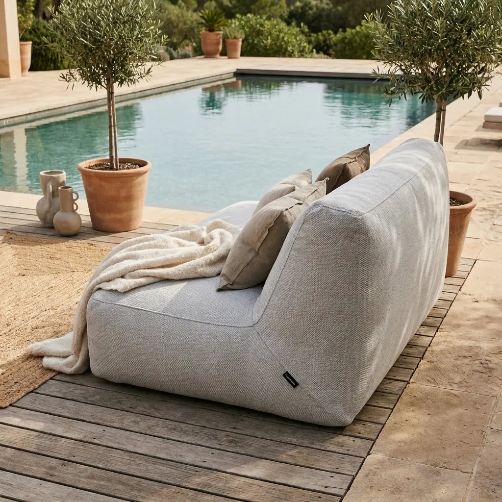 Sittsäck Soffa Tube Dunẽs Fluffy White styled on a wooden deck by a pool with a cozy throw and decorative pillows.