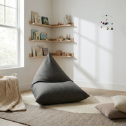 Sittsäck Barnfåtölj Razzy Nordic Grey in a cozy, modern nursery with wooden shelves, books, and a soft rug.
