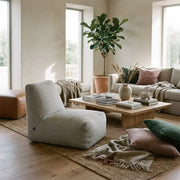 Modern living room with a neutral color palette, cozy textured furniture, a wooden coffee table, and a large fiddle leaf fig.